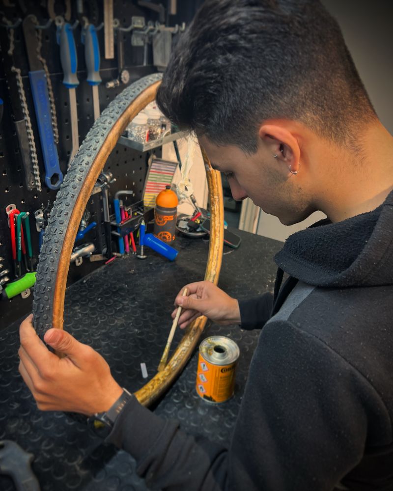 Mecánico trabajando en rueda de bicicleta en el taller SG Bikes Services